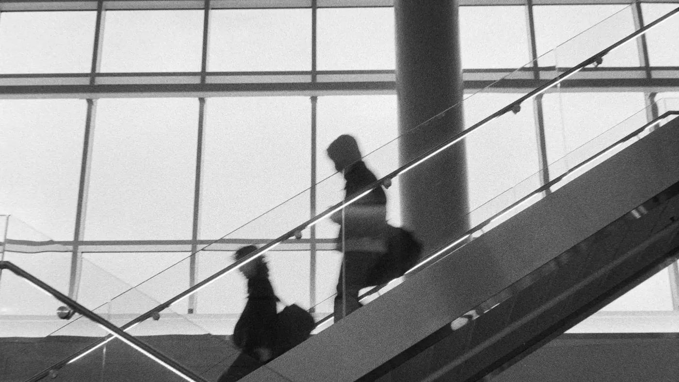 People on an escalator in black and white